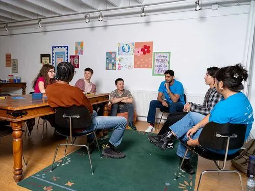 Students discussing and sitting around tables in a workshop