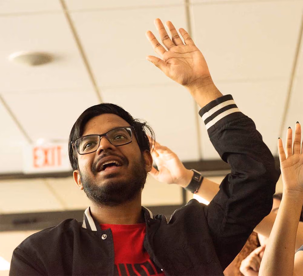 participant raising their hand indoors