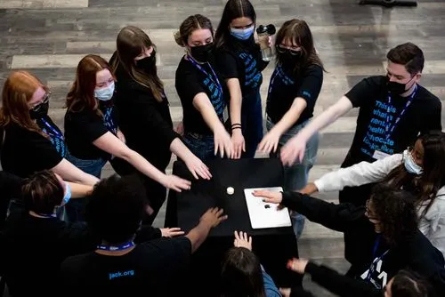 People reaching their hands out in a group huddle