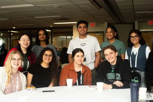 Group photo of 9 participants on a table