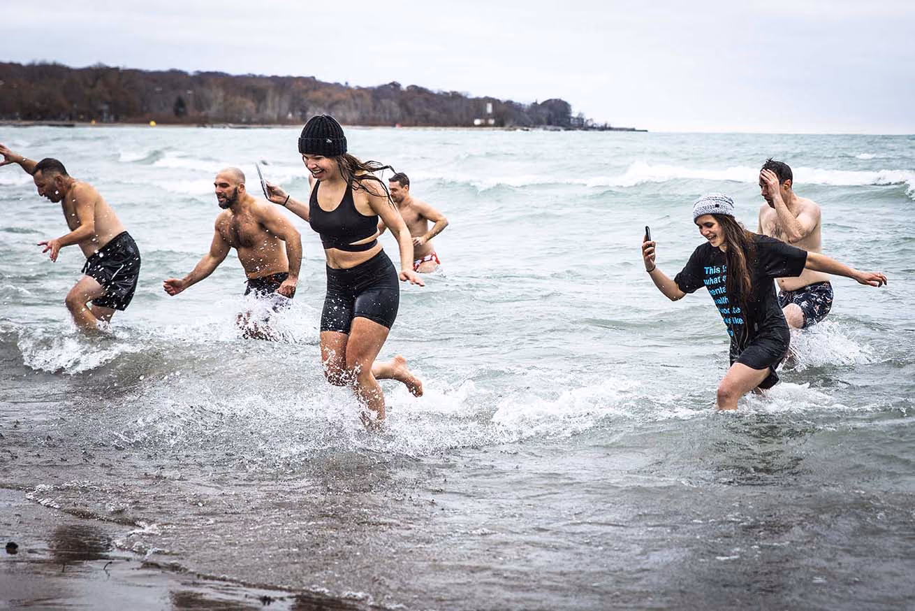Brainfreeze participants running out of a wave in a lake