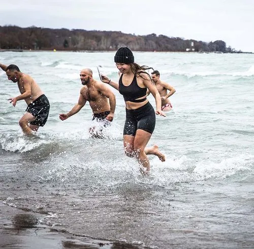 Brainfreeze participants running from a wave on a lake