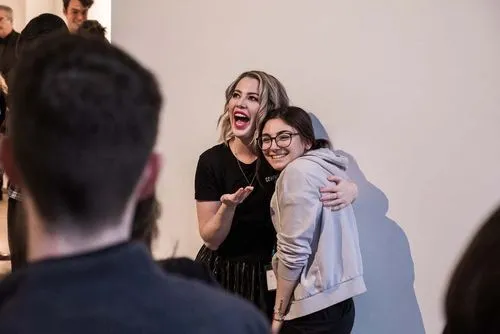 Two people posing for camera at a party, one participant in the foreground