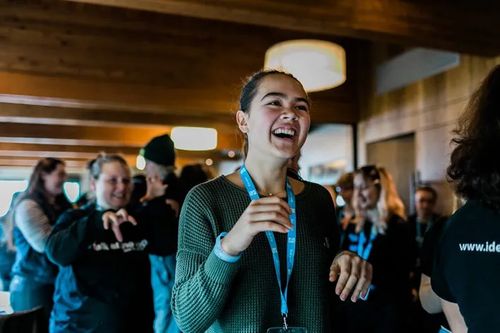 talks speaker laughing in front of  other participants