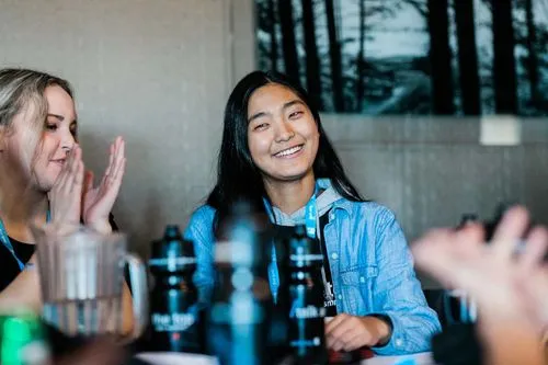 Participant sitting at table smiling around others