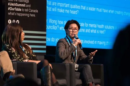 speaker sitting in a panel in front of a projector