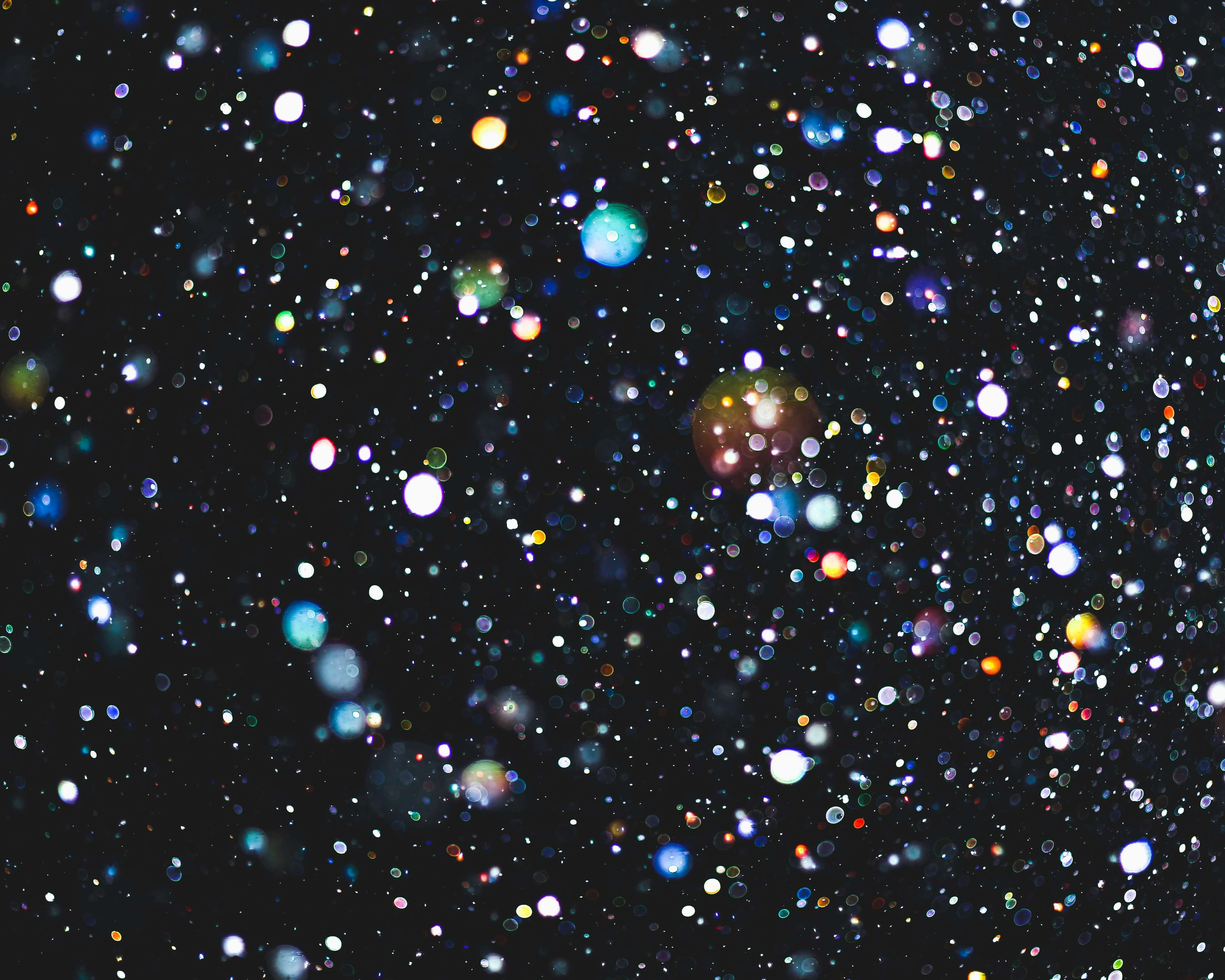 Close up image of rainbow glitter in a dark room