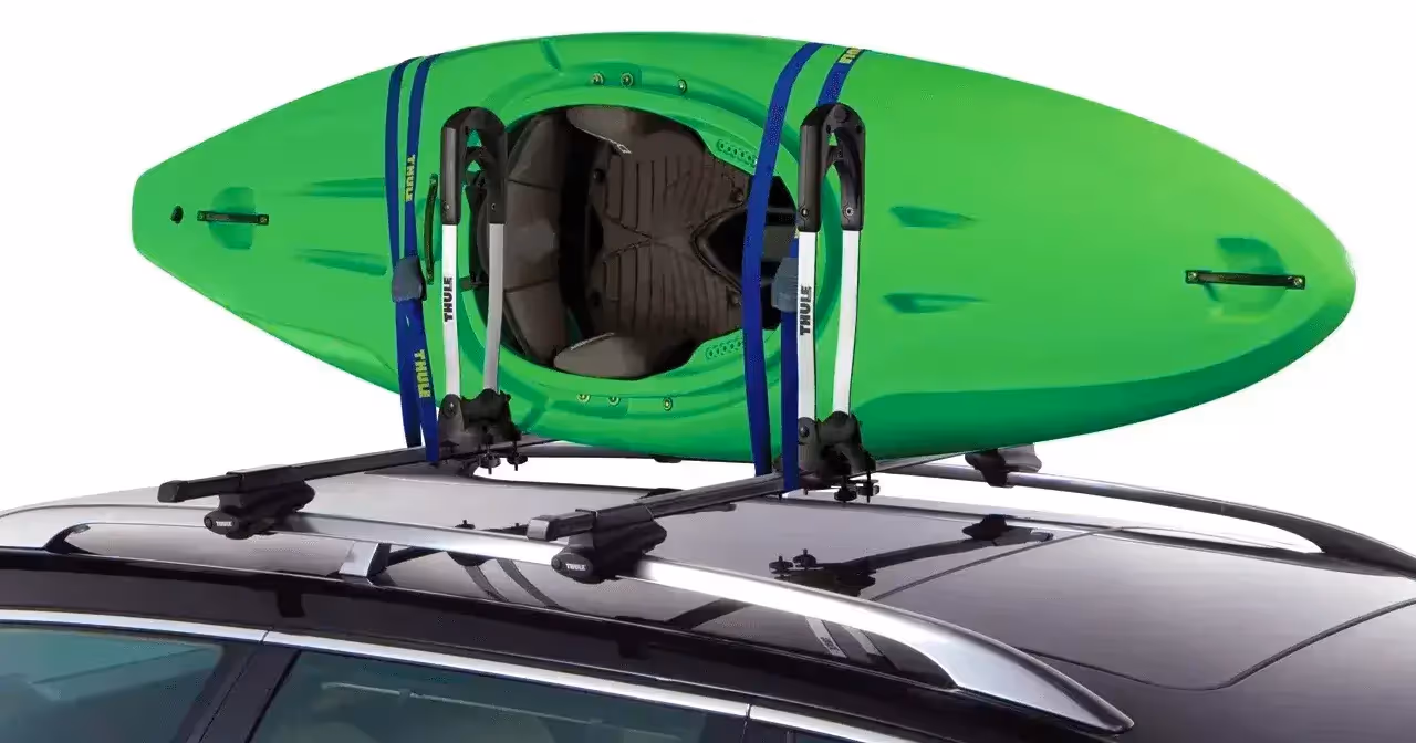 green kayak strapped to high-capacity vehicle roof rack