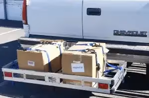 hitch cargo carrier with two boxes behind white Chevrolet van