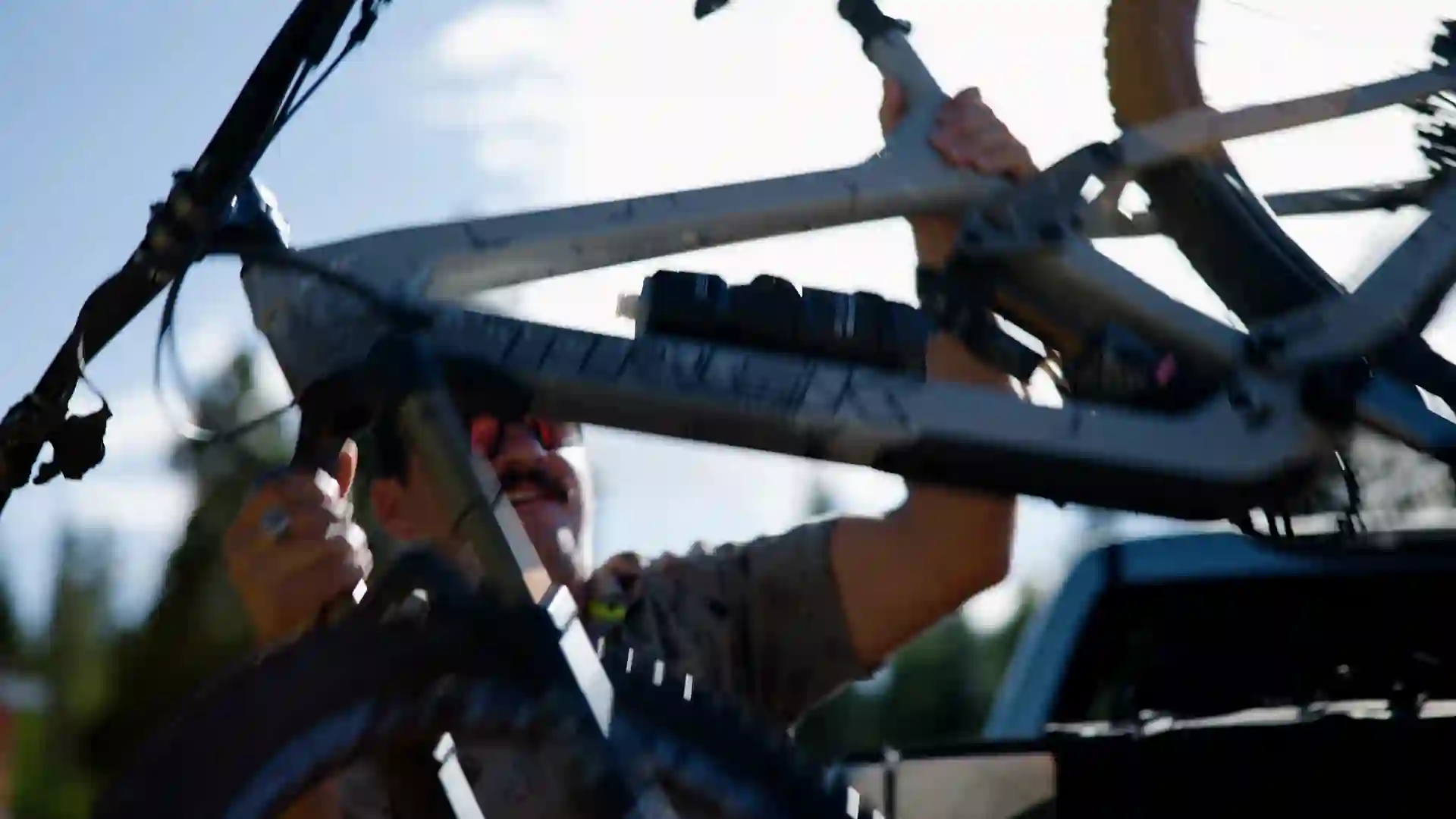 Close-up cinematic shot of Mark Owens unloading a mountain bike from the back of a Toyota Tundra, filmed by Checked In Media for a Hilltop Bank video production advertisement in Casper, Wyoming.