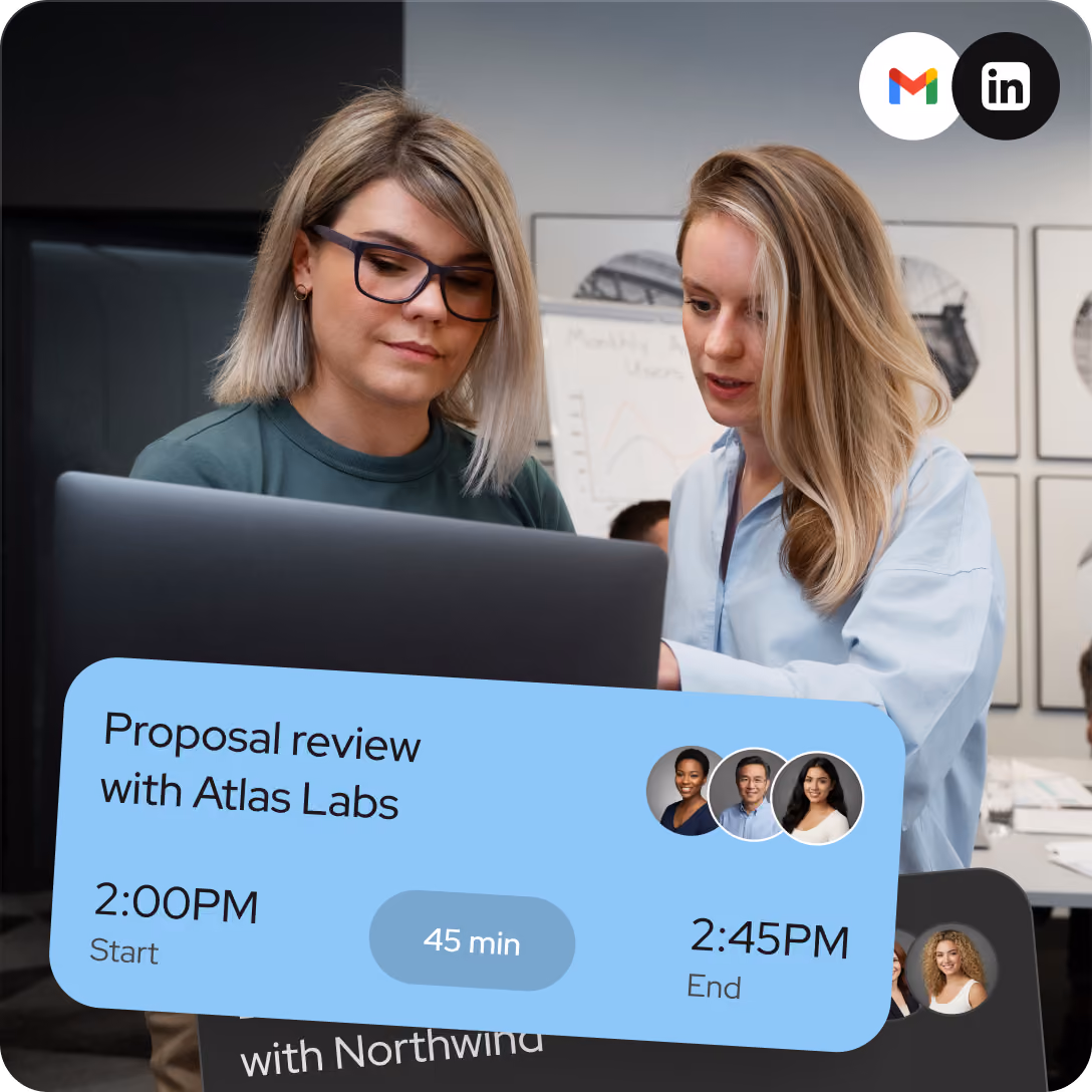 Two women collaborating and looking at a laptop screen in an office setting, with a calendar event overlay showing a proposal review meeting with Atlas Labs from 2:00 PM to 2:45 PM, attended by three people.