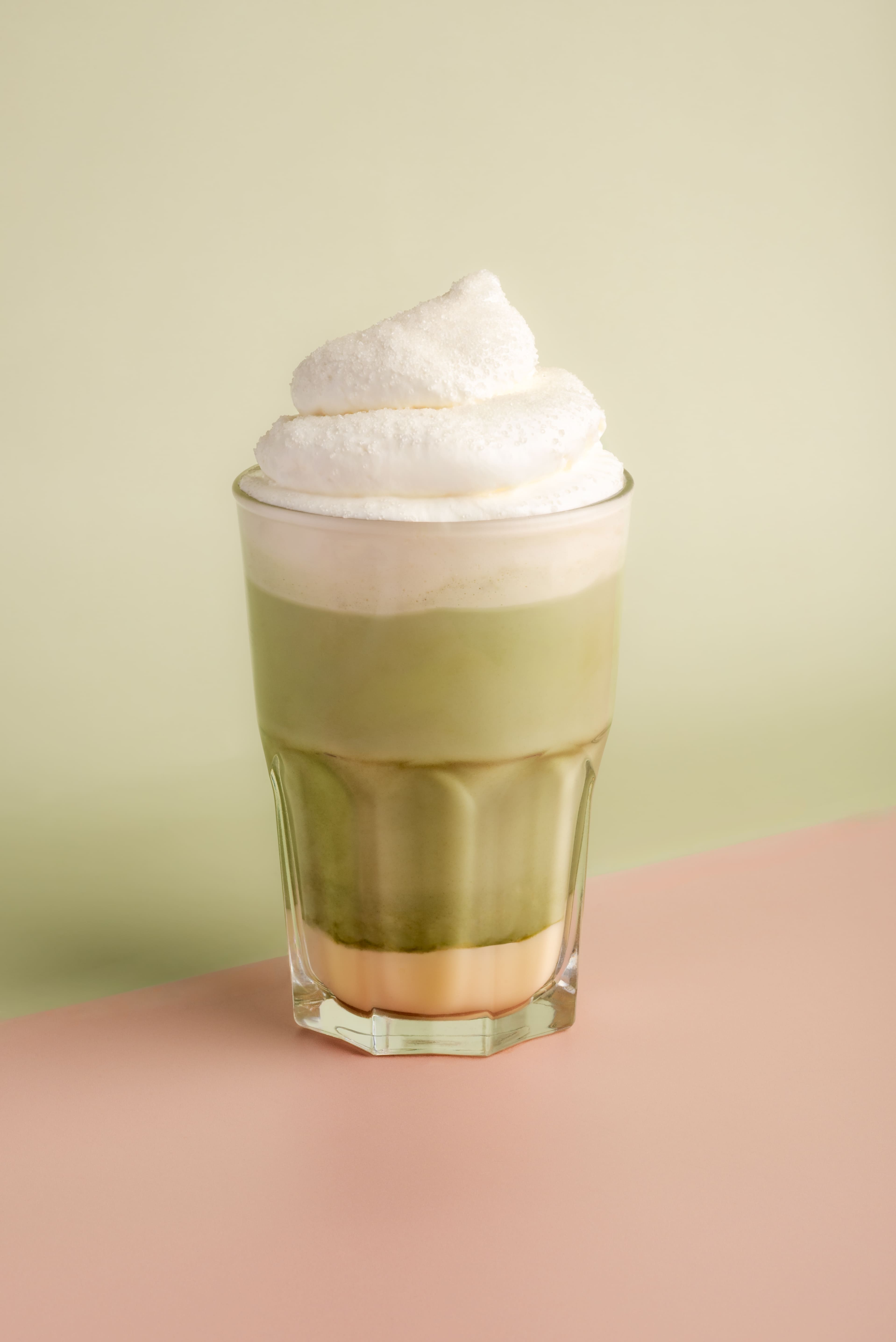 Nous pouvons voir la matcha Gold Cream sur un fond rose et vert 