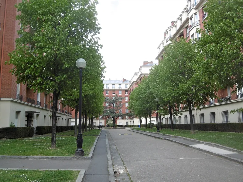 Allée arborée entre les immeubles de brique de la cité-jardin des Grésillons à Asnières