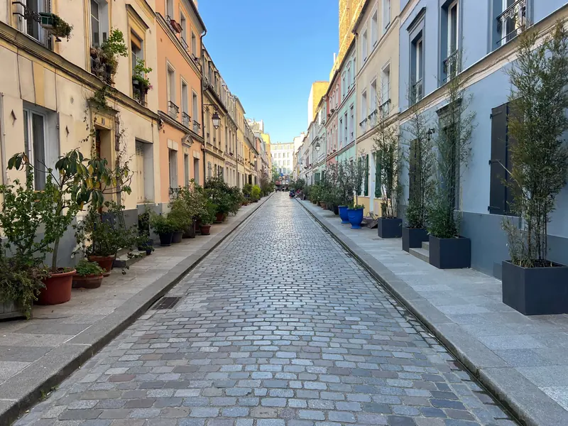 Rue Crémieux pavée, aux façades pastel et aux plantes en pot, dans le 12e