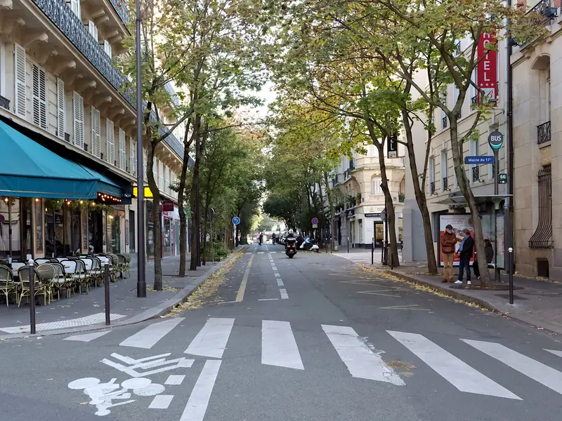 Rue des Batignolles arborée, avec ses immeubles et ses terrasses, dans le 17e