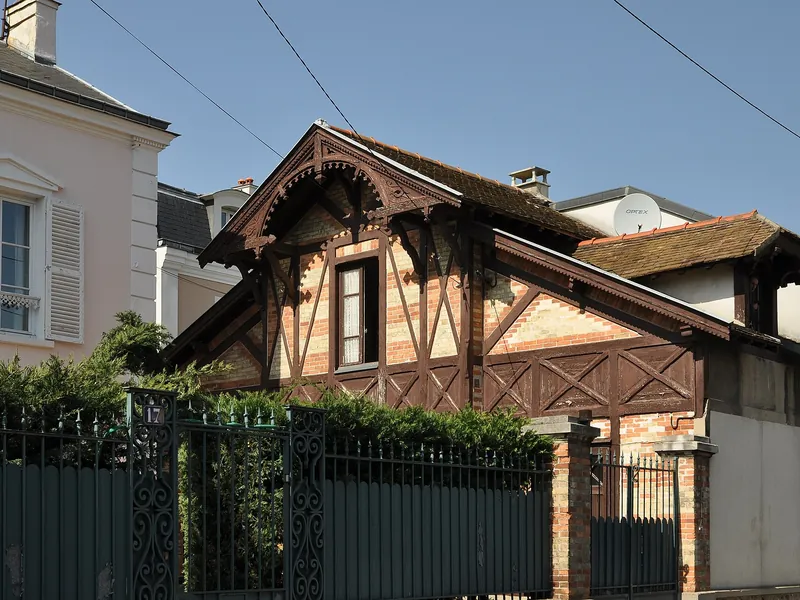 Maison à pans de bois derrière sa grille rue Camille-Périer à Chatou