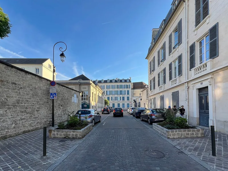 Rue des Écuyers bordée de maisons anciennes et d'un mur de pierre à Saint-Germain-en-Laye
