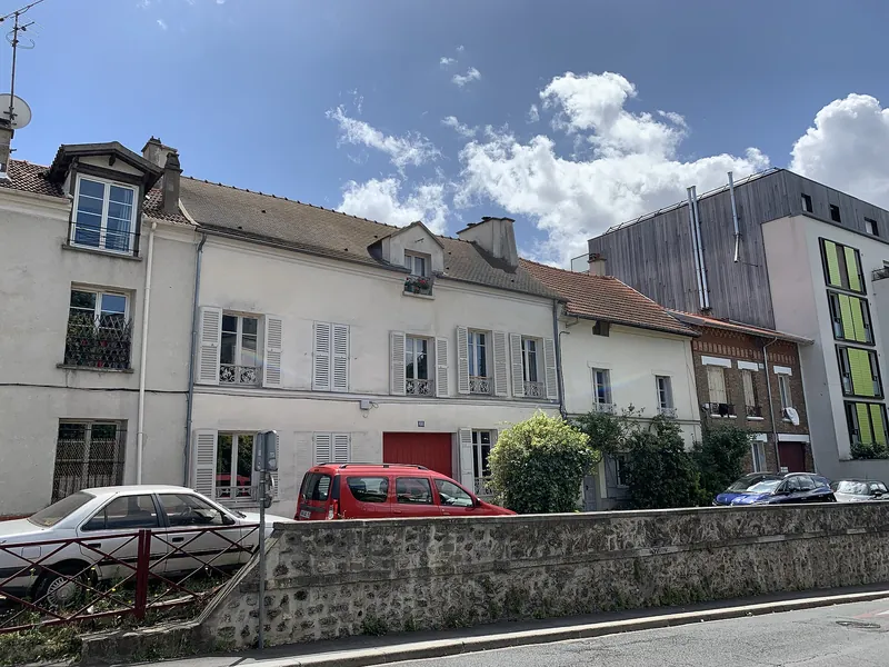 Maisons anciennes alignées derrière un mur de pierre, rue de Rosny à Montreuil