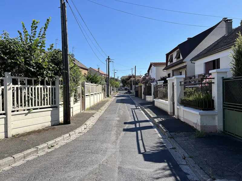 Rue de pavillons aux clôtures blanches à Drancy