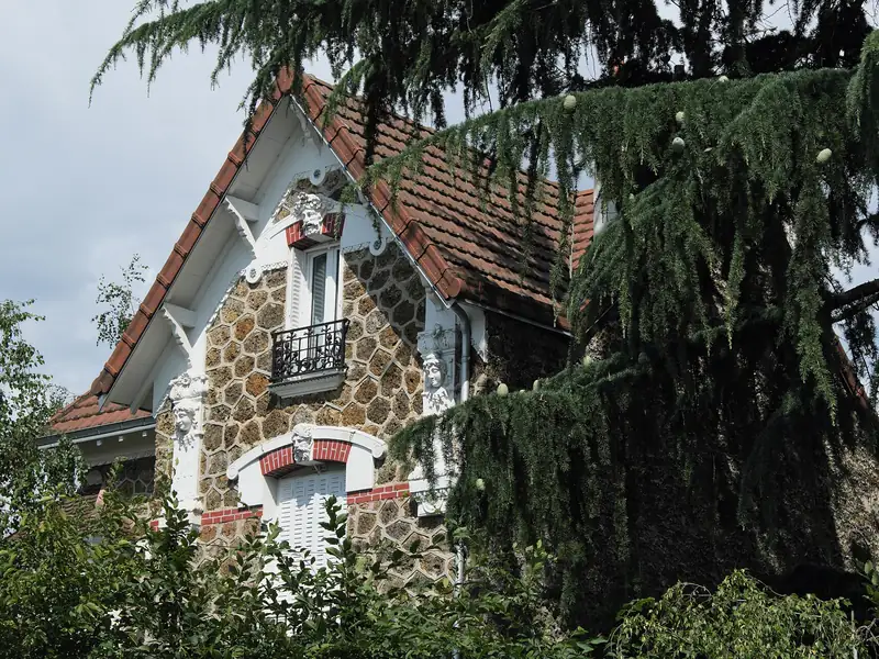 Maison en meulière à décor de brique sous un grand cèdre, boulevard d'Aulnay à Villemomble