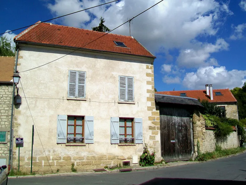 Maison de village crépie aux volets bleus, à l'angle de deux rues d'Auvers-sur-Oise
