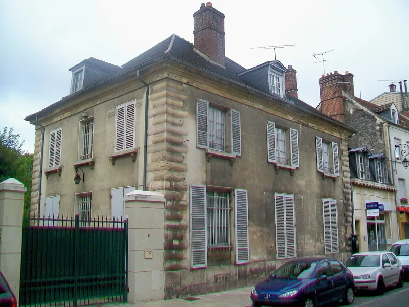 Maison bourgeoise en pierre aux volets gris dans la Grande-Rue de L'Isle-Adam