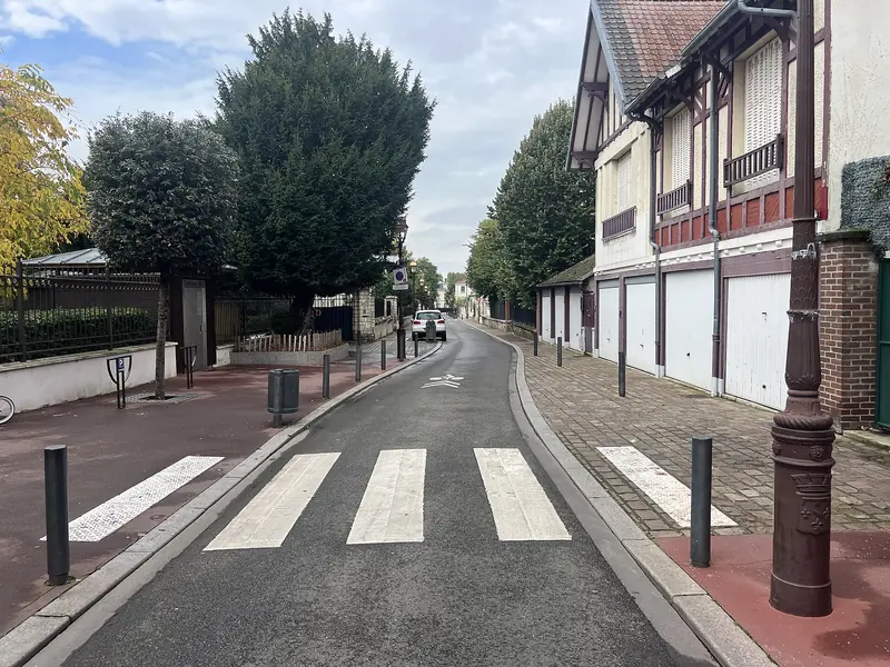 Rue d'Enghien-les-Bains longée par une maison à pans de bois bâtie au-dessus de garages