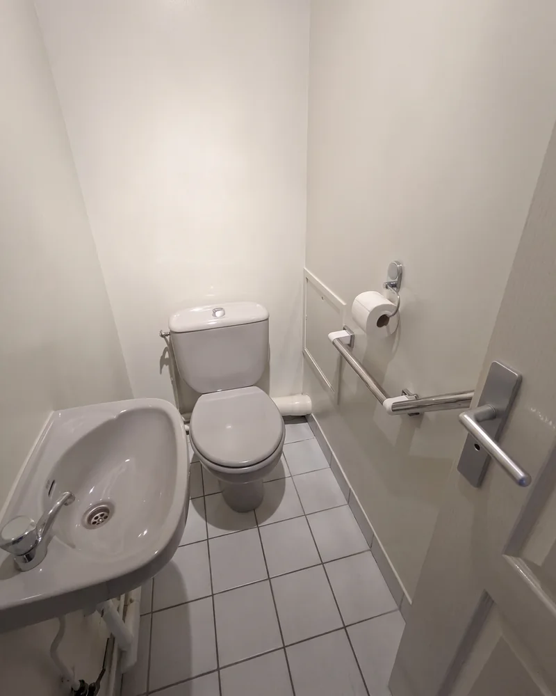 Après&nbsp;: les toilettes, avec une barre d'appui coudée fixée au&nbsp;mur à&nbsp;droite de&nbsp;la&nbsp;cuvette