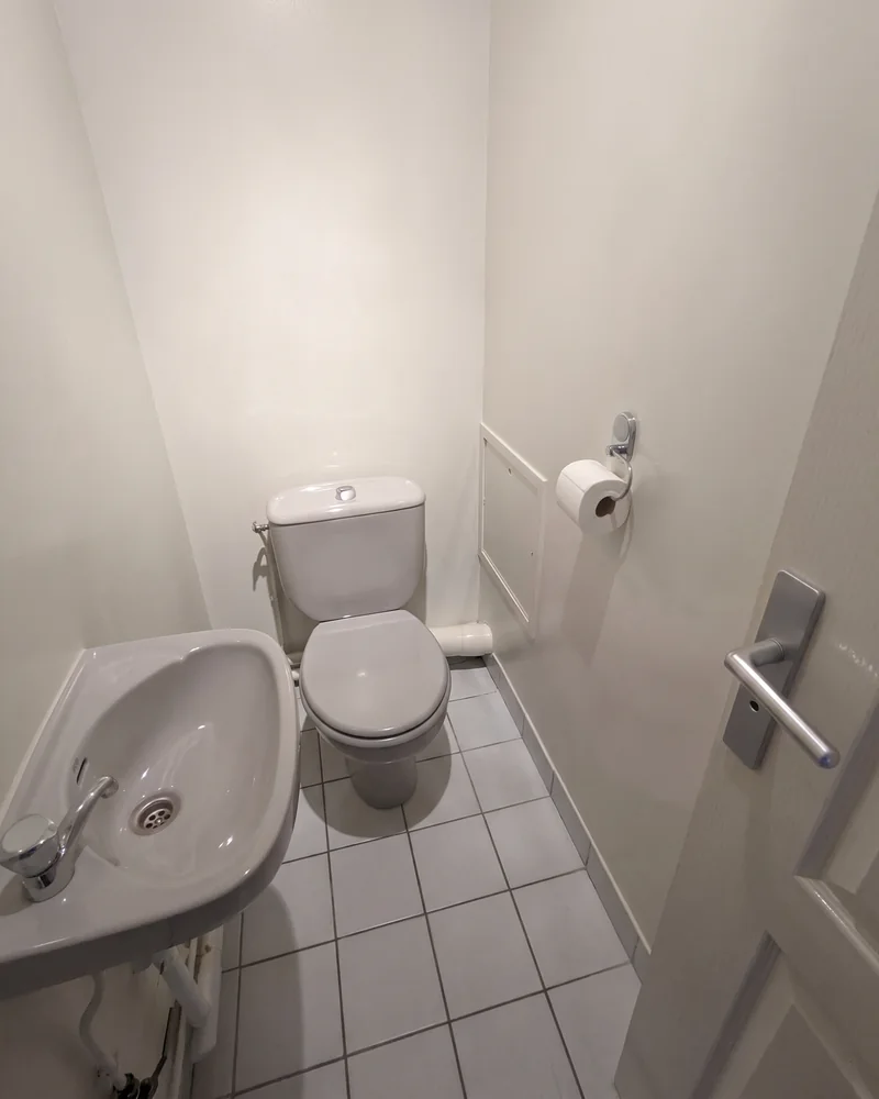 Avant&nbsp;: les toilettes, étroites, avec un&nbsp;petit lave-mains à&nbsp;gauche