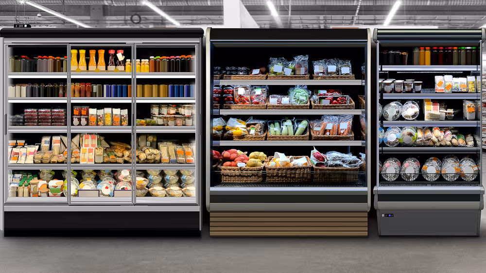 Grocery store aisle with shelves of beverages, vegetables, and packaged foods in a refrigerated display.