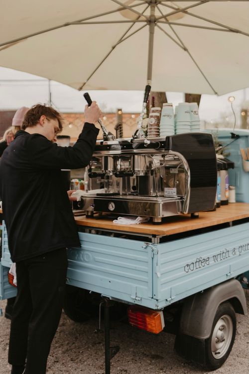 Barista pulling a shot of espresso on a mobile Vespa espresso bar