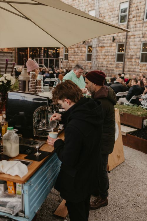 Baristas taking orders and pour latte art for a private event with a mobile espresso scooter