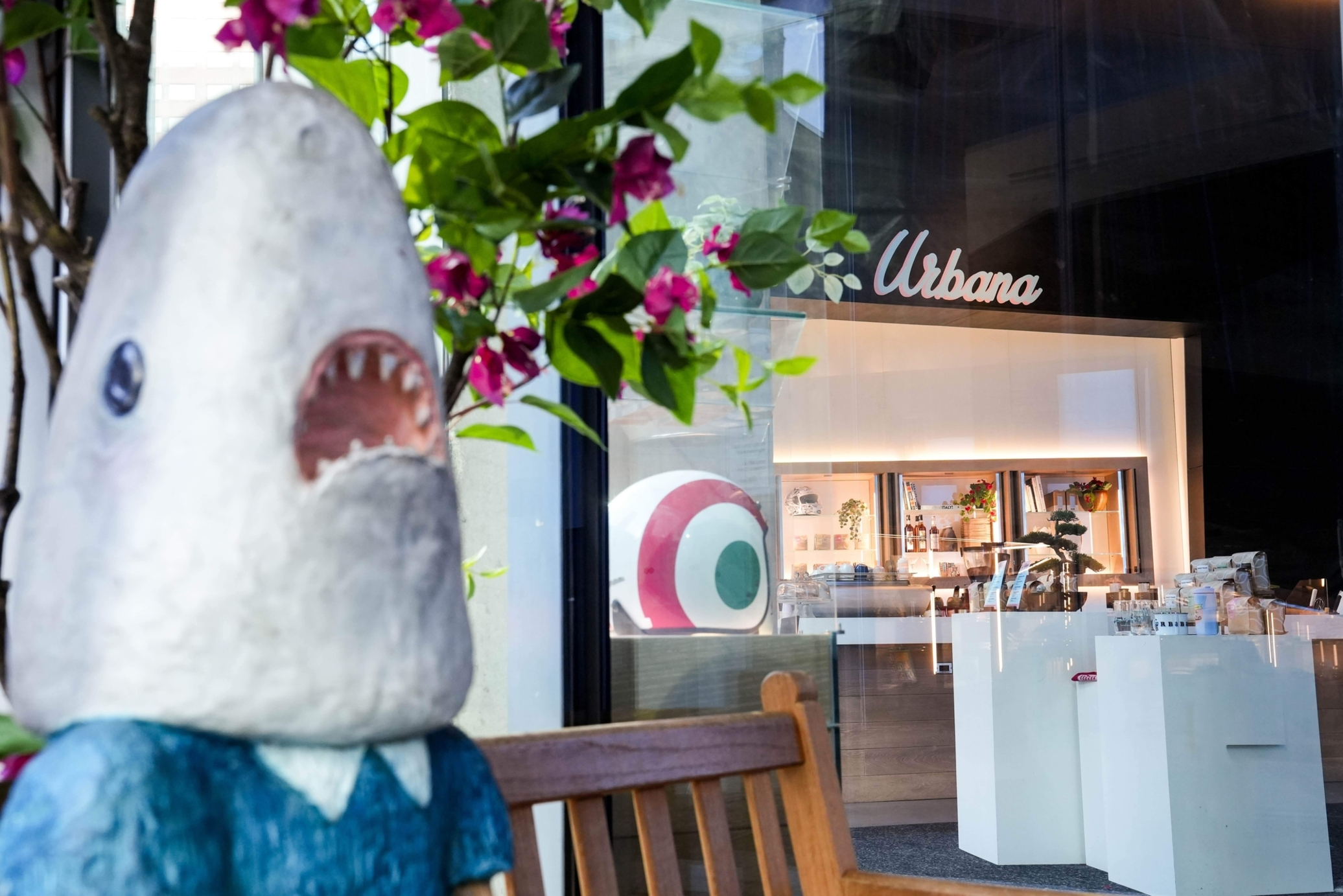 Classical statue wearing a blue headband with a disembodied skeletal hand holding a light bulb on the left and a blue boxing glove on the right against a pink and blue background.