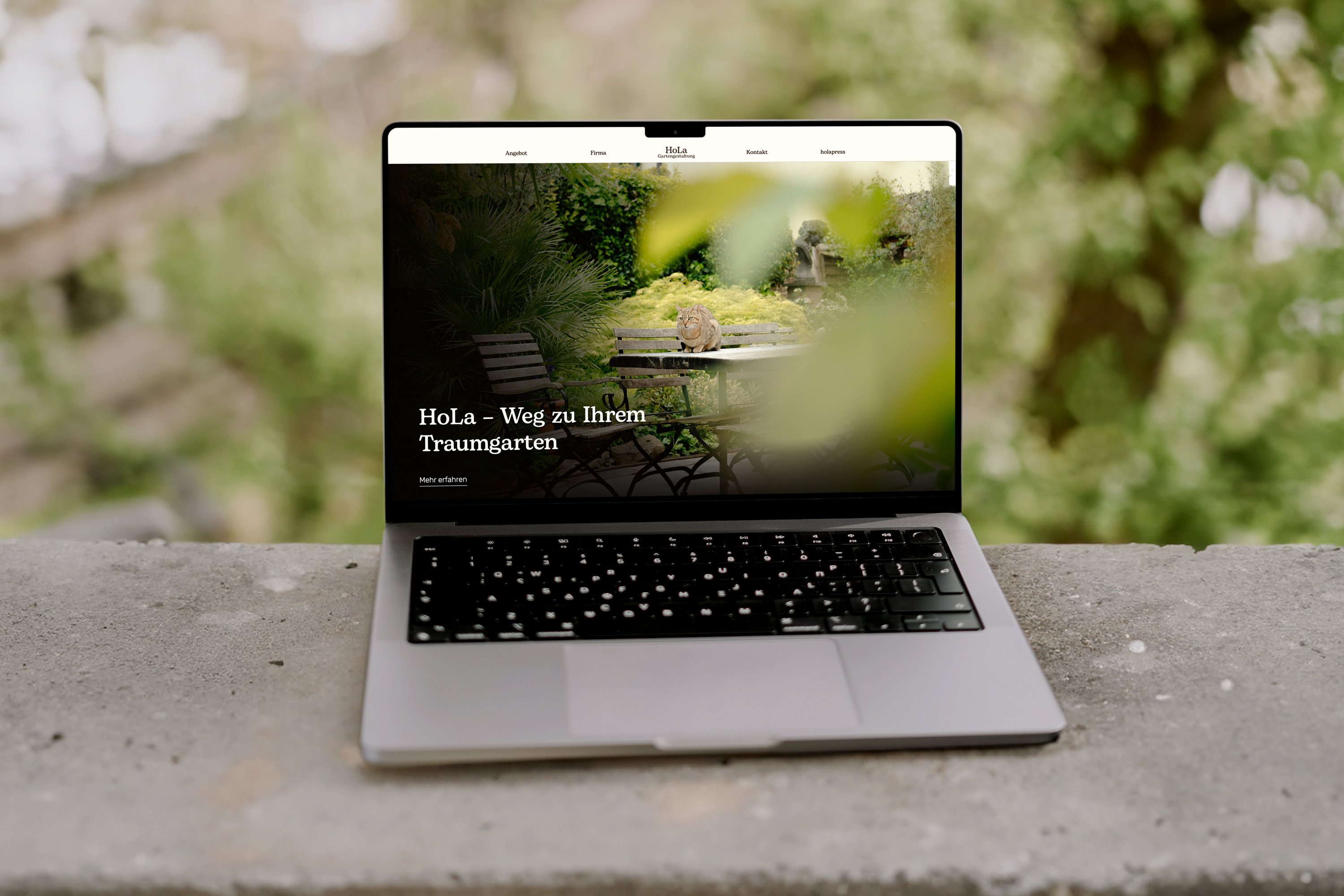 Ein offener Laptop. Auf dem Laptop ist die Website von HoLa Gartengestaltung zu sehen.