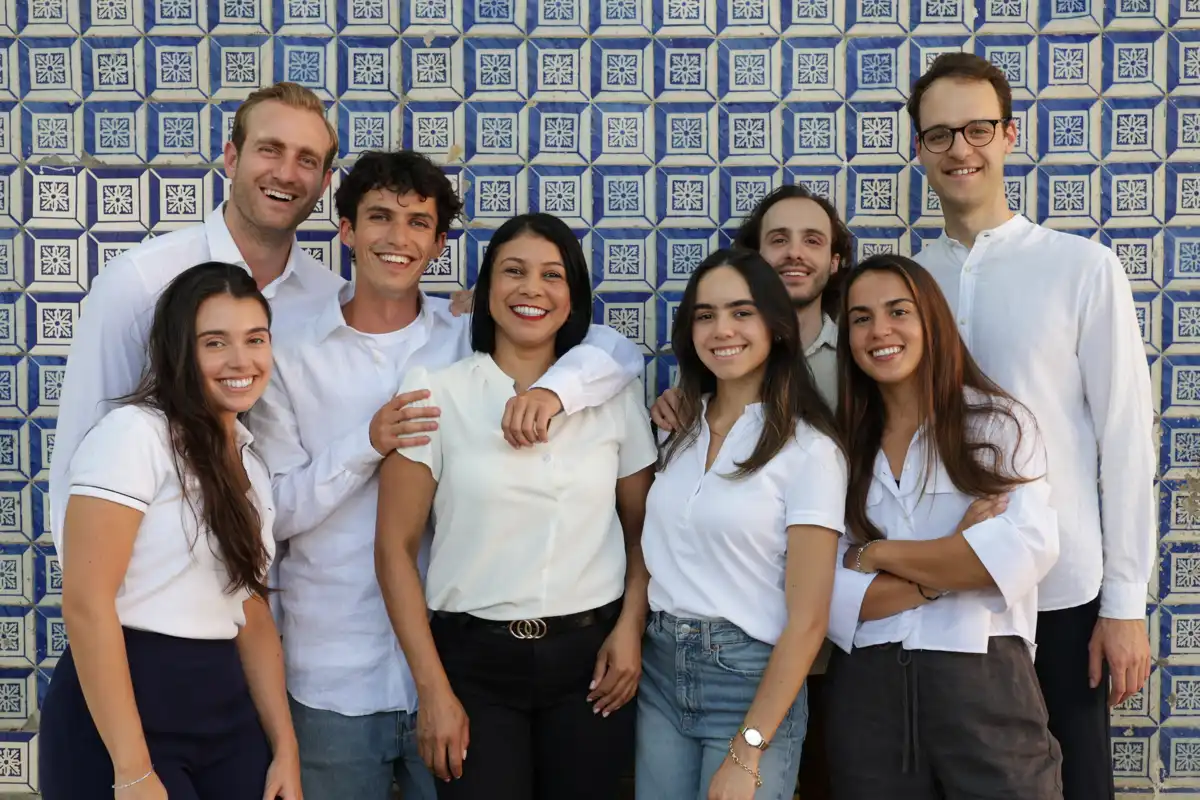 The Bleisured team altogether, standing in front of a blue Azulejo wall in Lisbon