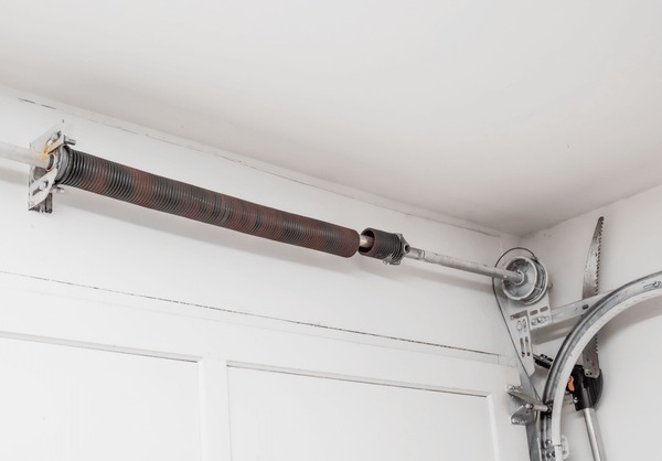 Close-up photo of worn-out broken garage door spring on the floor