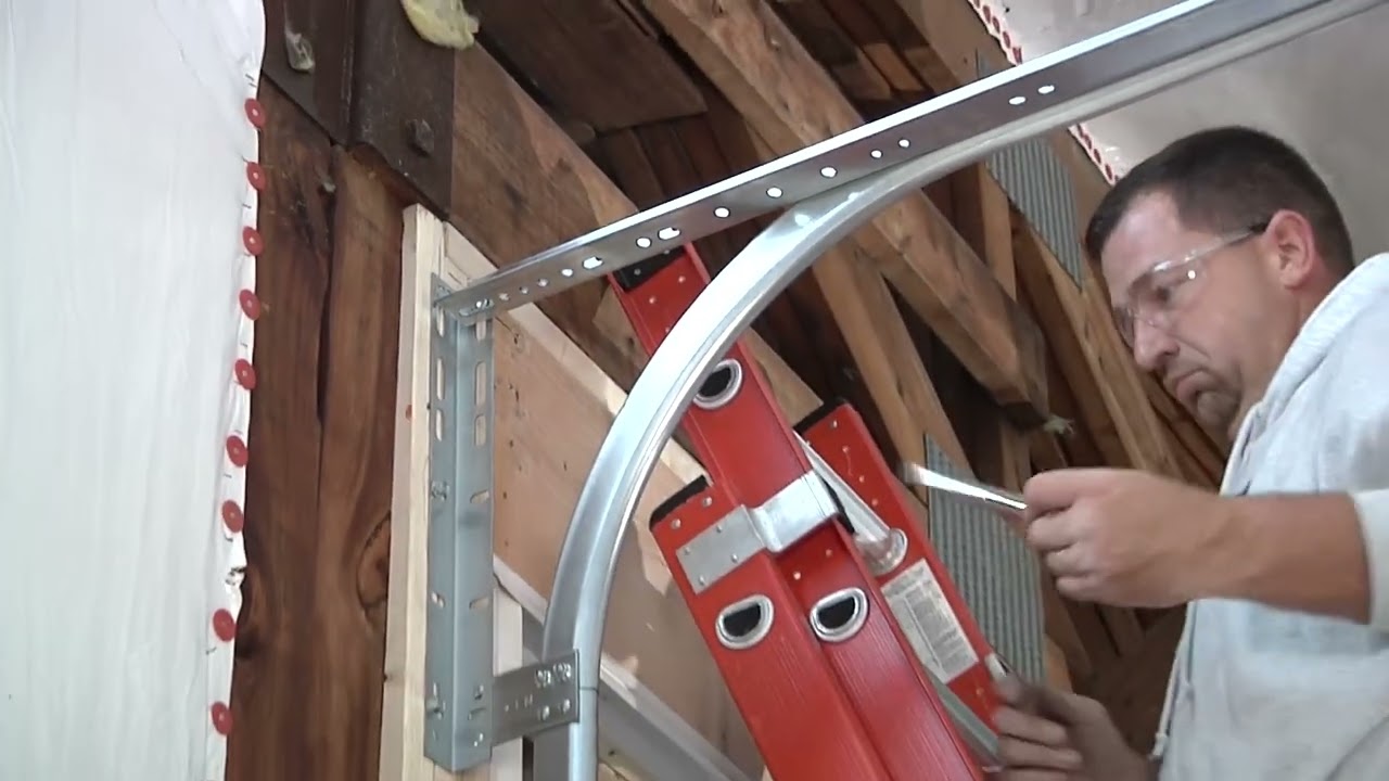 Technician fixing garage door track tools demonstration