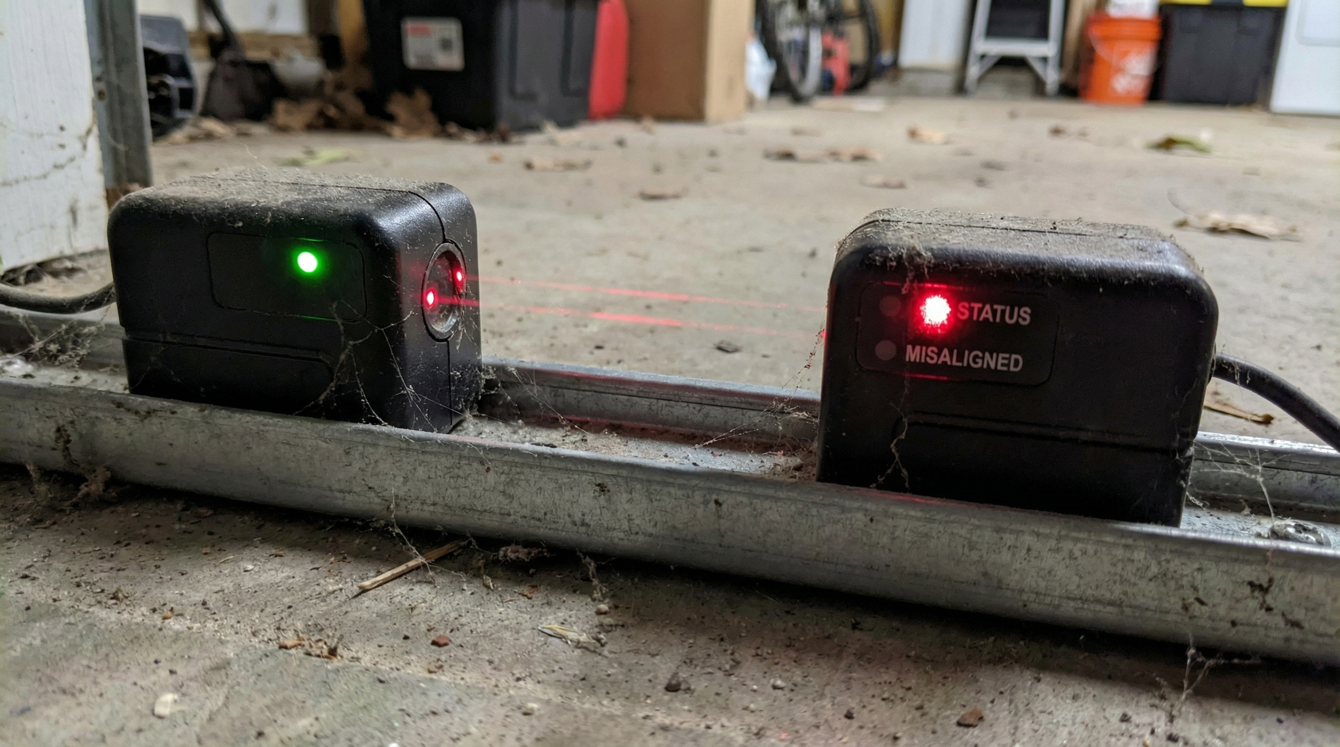 close-up of garage door safety sensors showing misalignment indicators