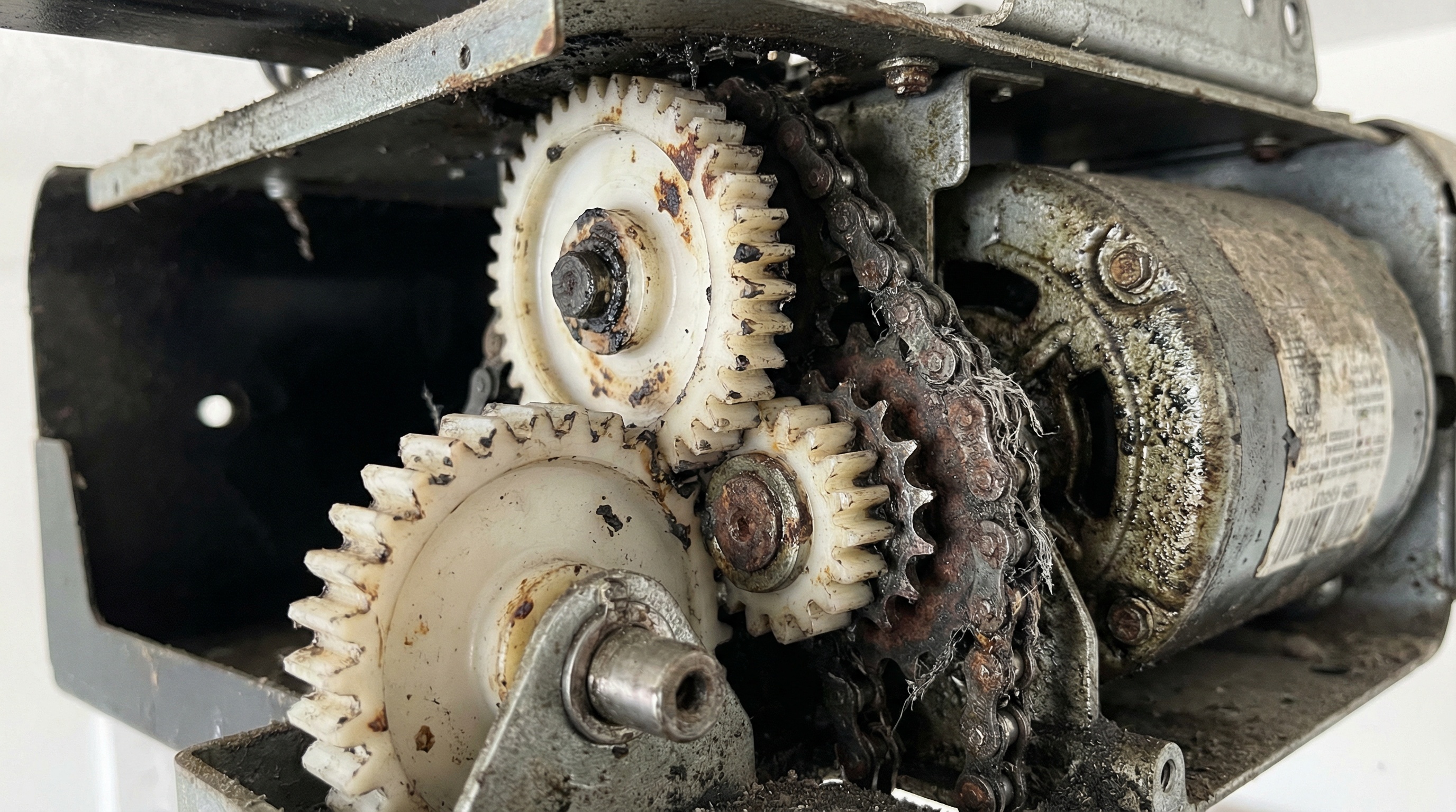 Close-up of worn garage door opener gears showing grinding damage