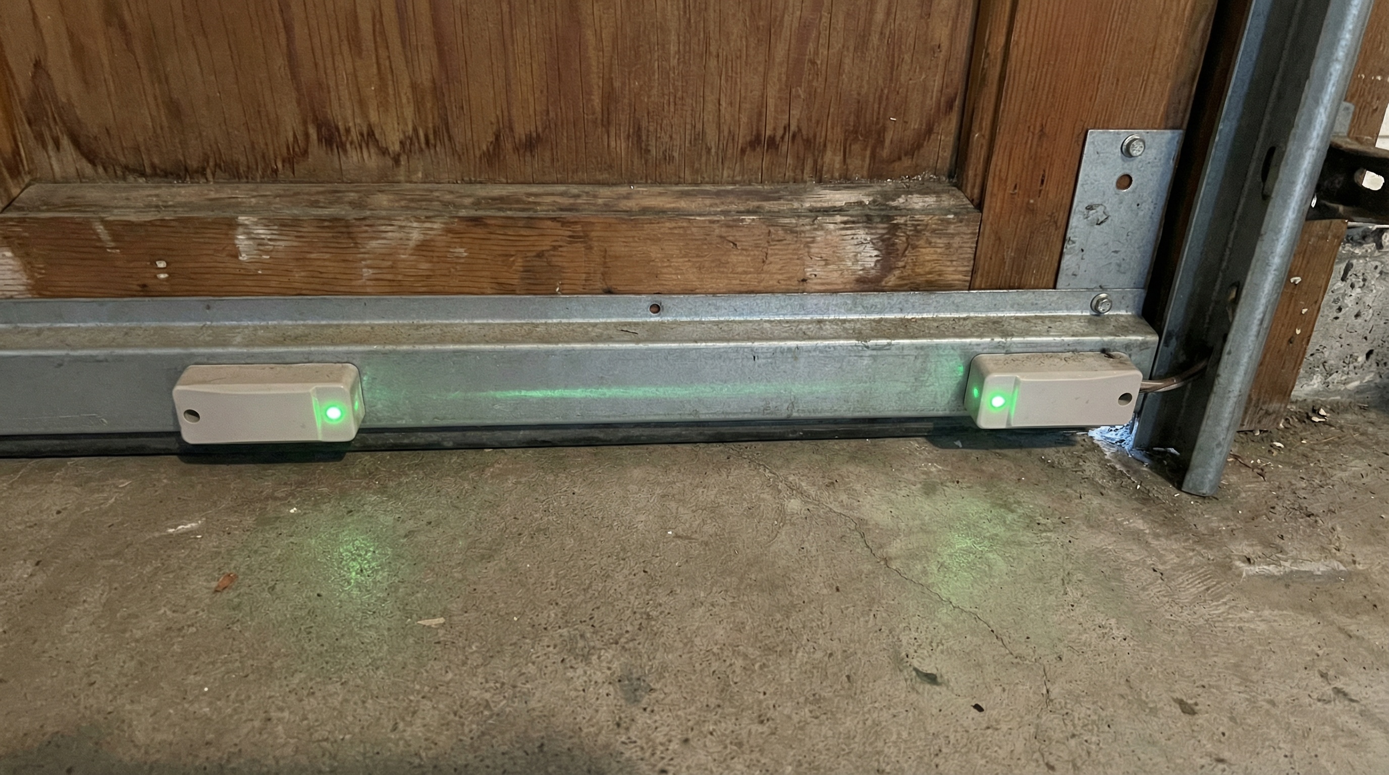 Garage door safety sensors alignment check showing photo eye sensors on both sides