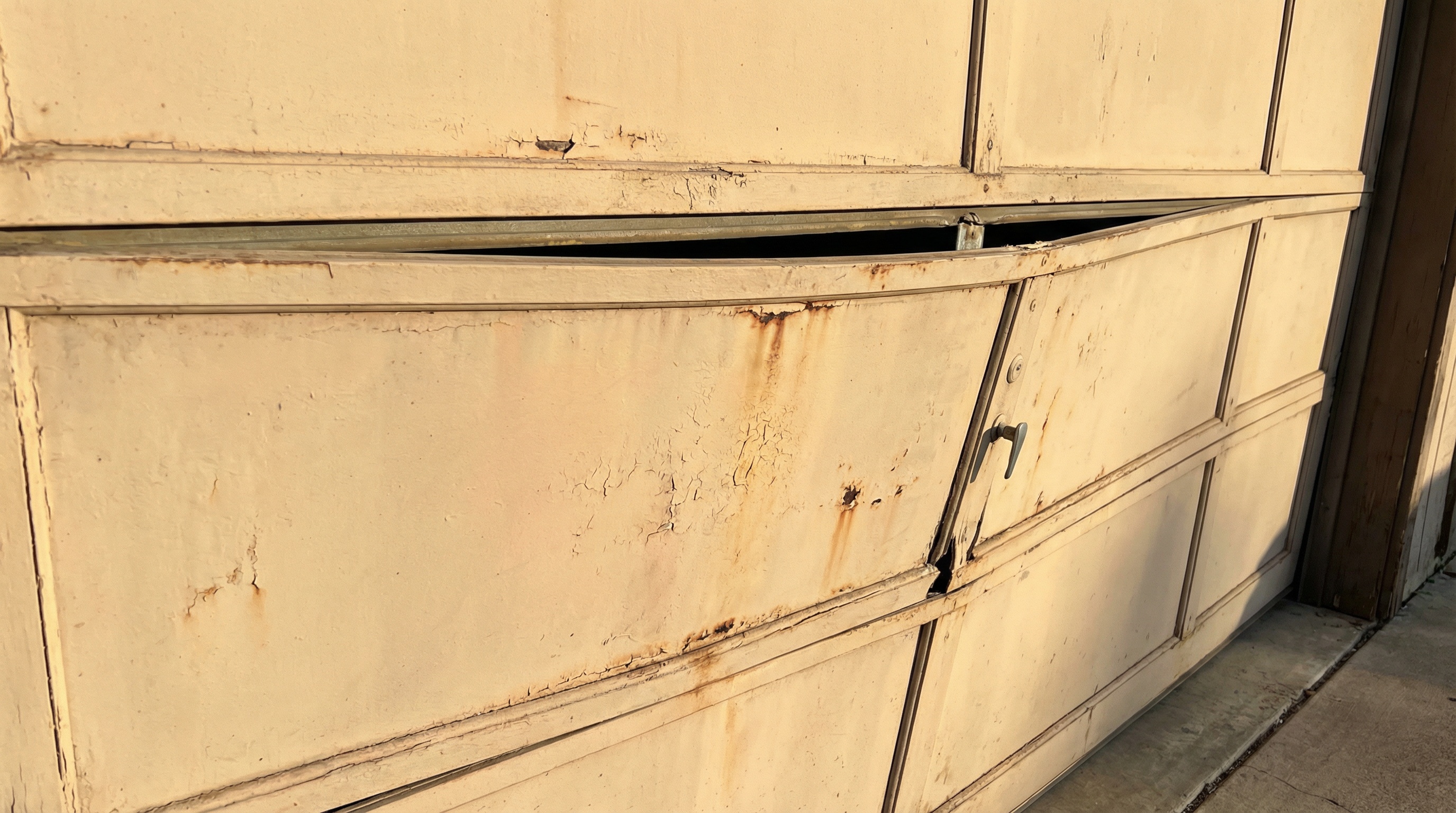 Warped garage door panel showing visible bowing and misalignment in Wisconsin cold