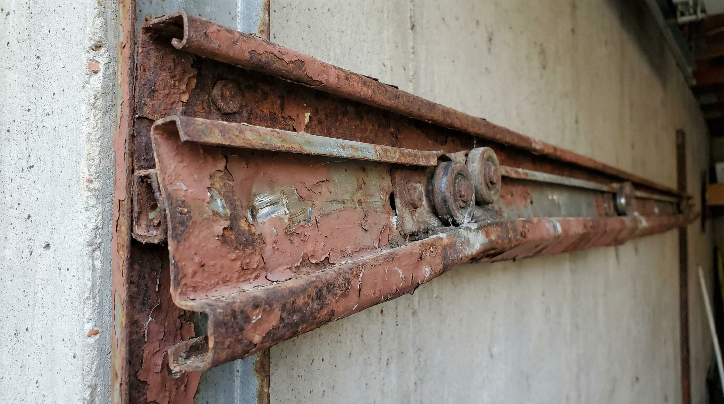 Worn garage door tracks showing signs of damage and need for replacement