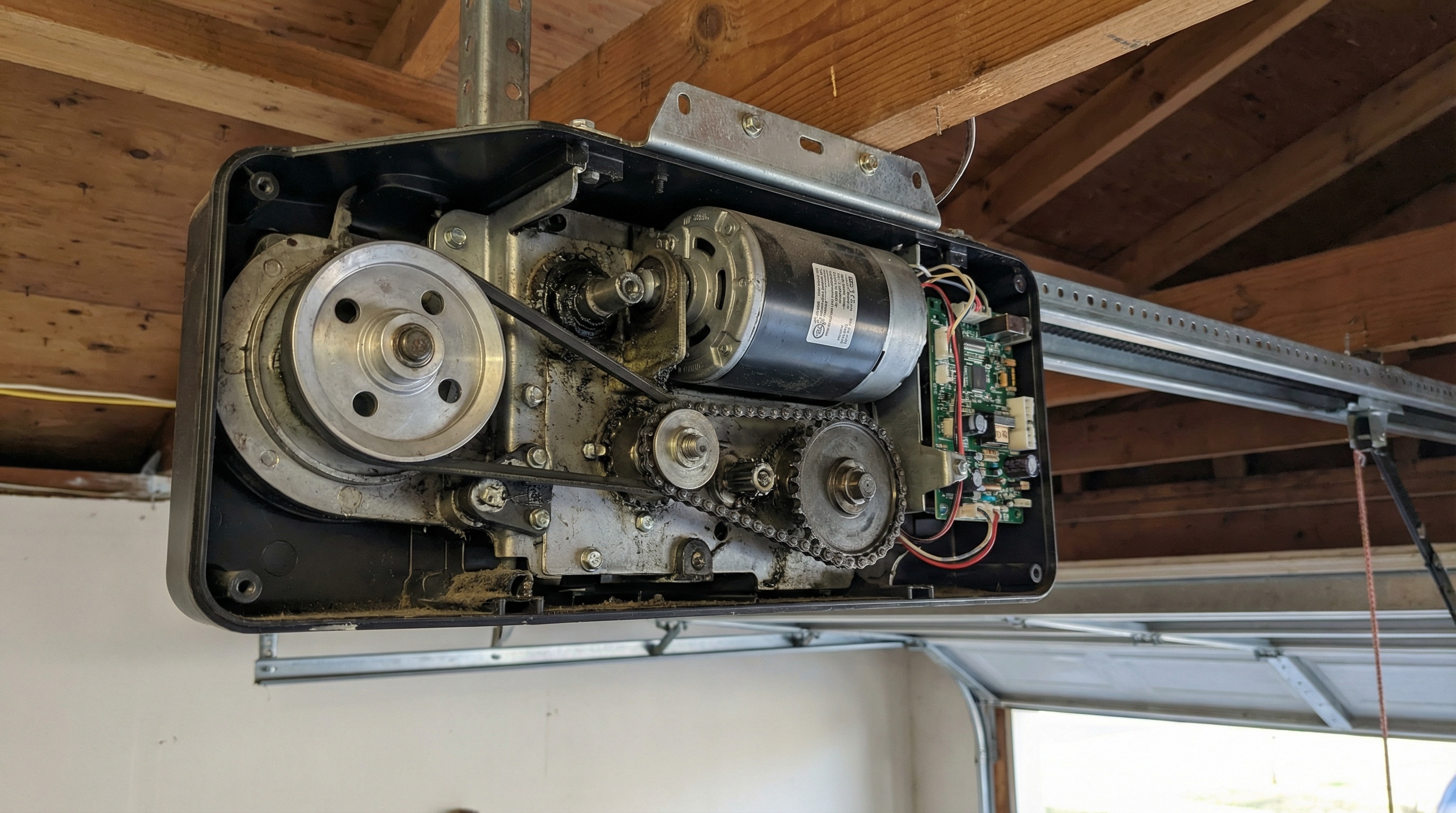 Garage door opener motor unit mounted on ceiling showing mechanical components