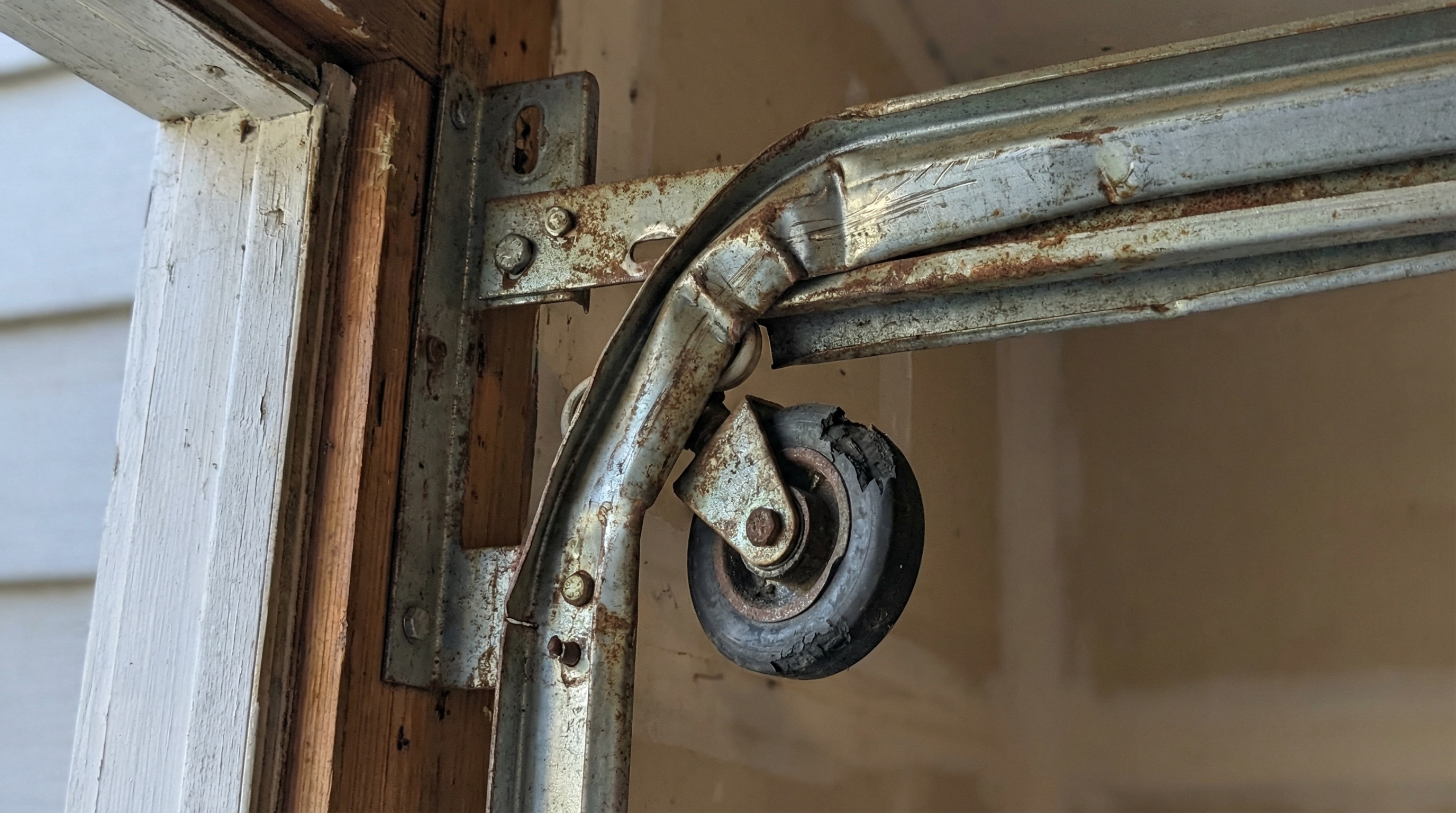 Worn garage door rollers and track misalignment