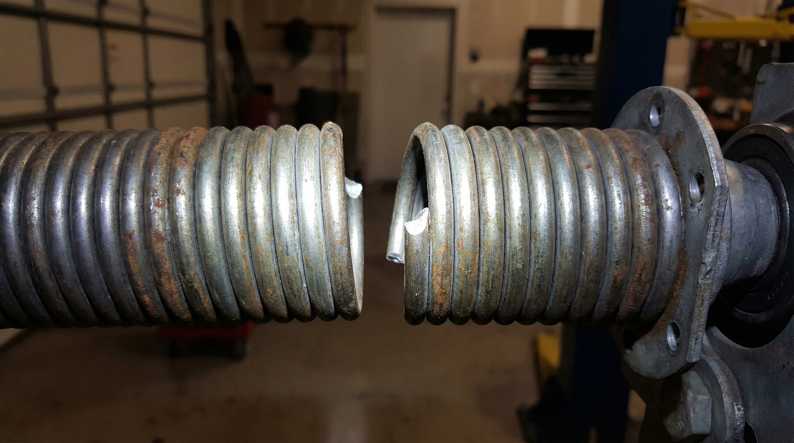 Broken torsion spring with visible gap in coils