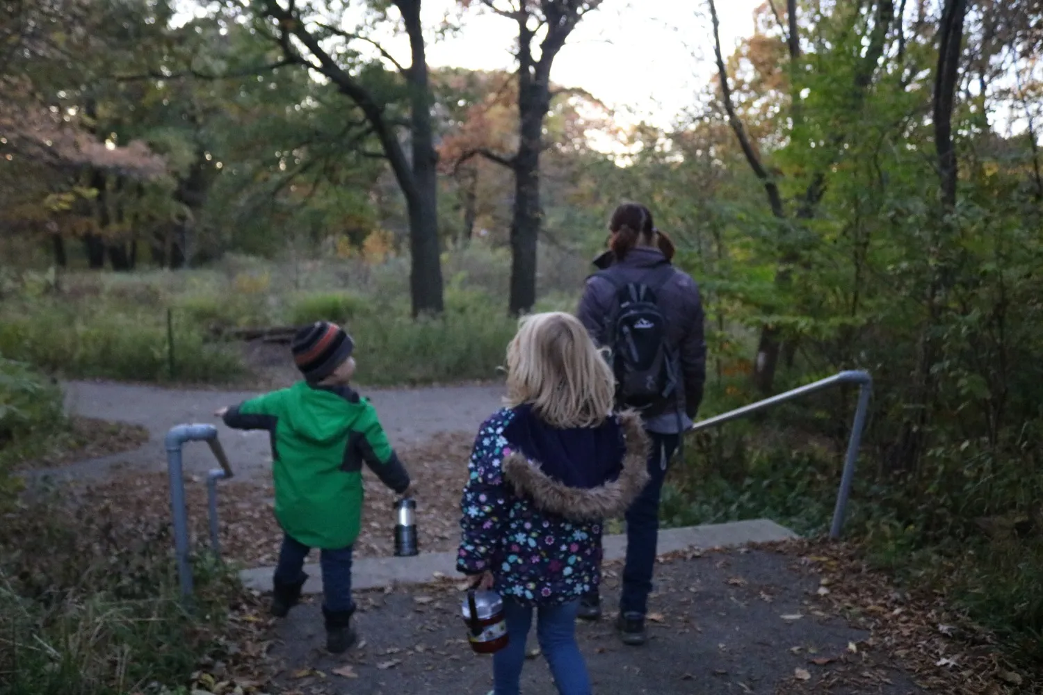 Adult and two children hiking at dusk
