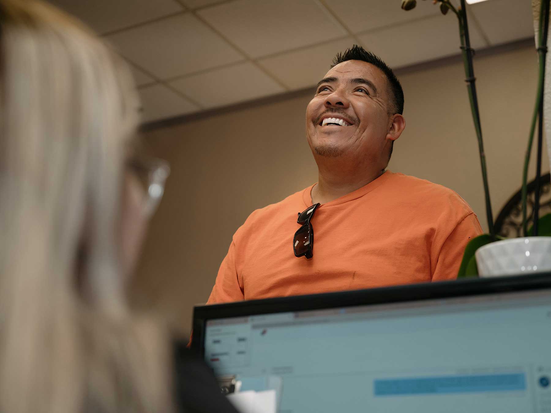 Man stands at at reception desk and smiling