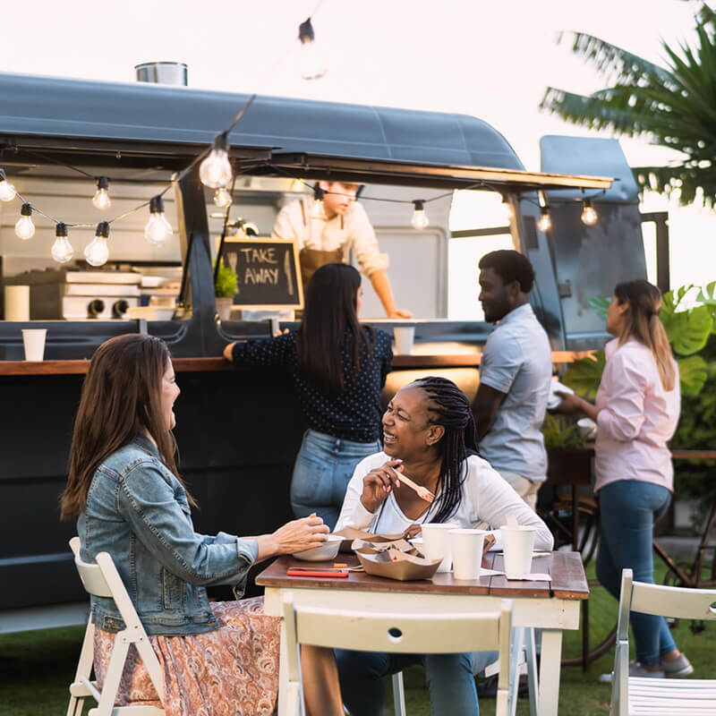 An image used to promote Google Ads for local business services - showing a couple of people at food truck sharing a meal and smiling at one another.