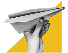 hand holding paper airplane with geometric shape in background