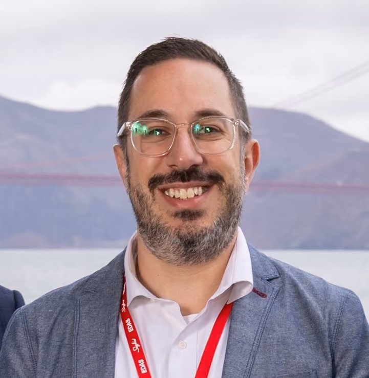Portrait of Hoffend smiling at an event with mountains in the background.